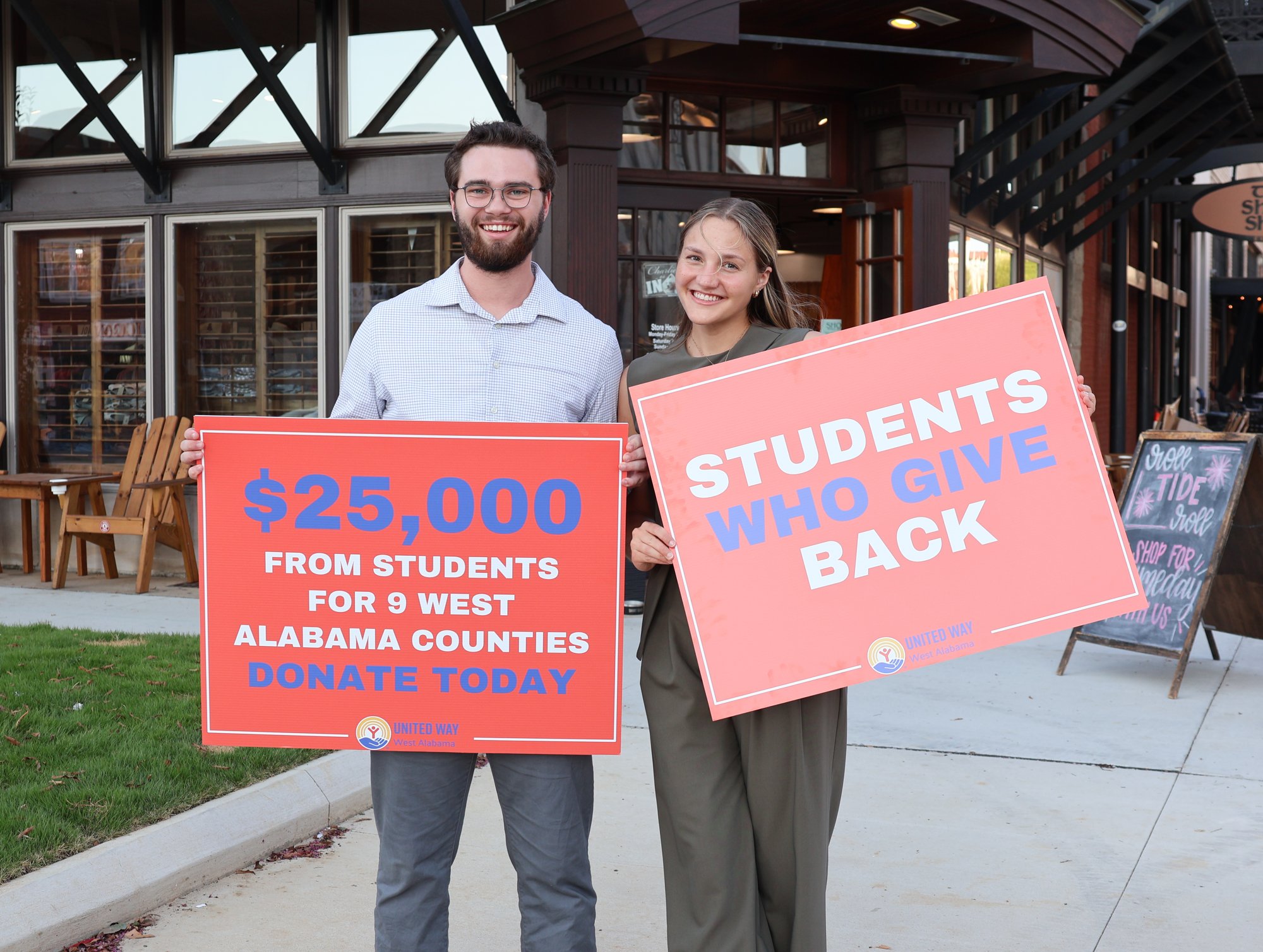 TP1K board members Garrett McNeil and Piper Larkin holding United Way campaign signs